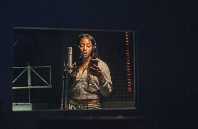 Female singer in recording studio with headphones, microphone, music stand, and acoustic foam panels on dark background